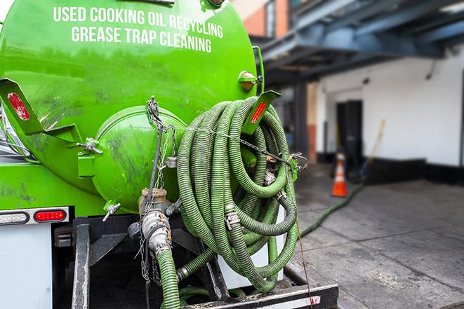 a grease trap being pumped by a sanitation technician in Coppell TX